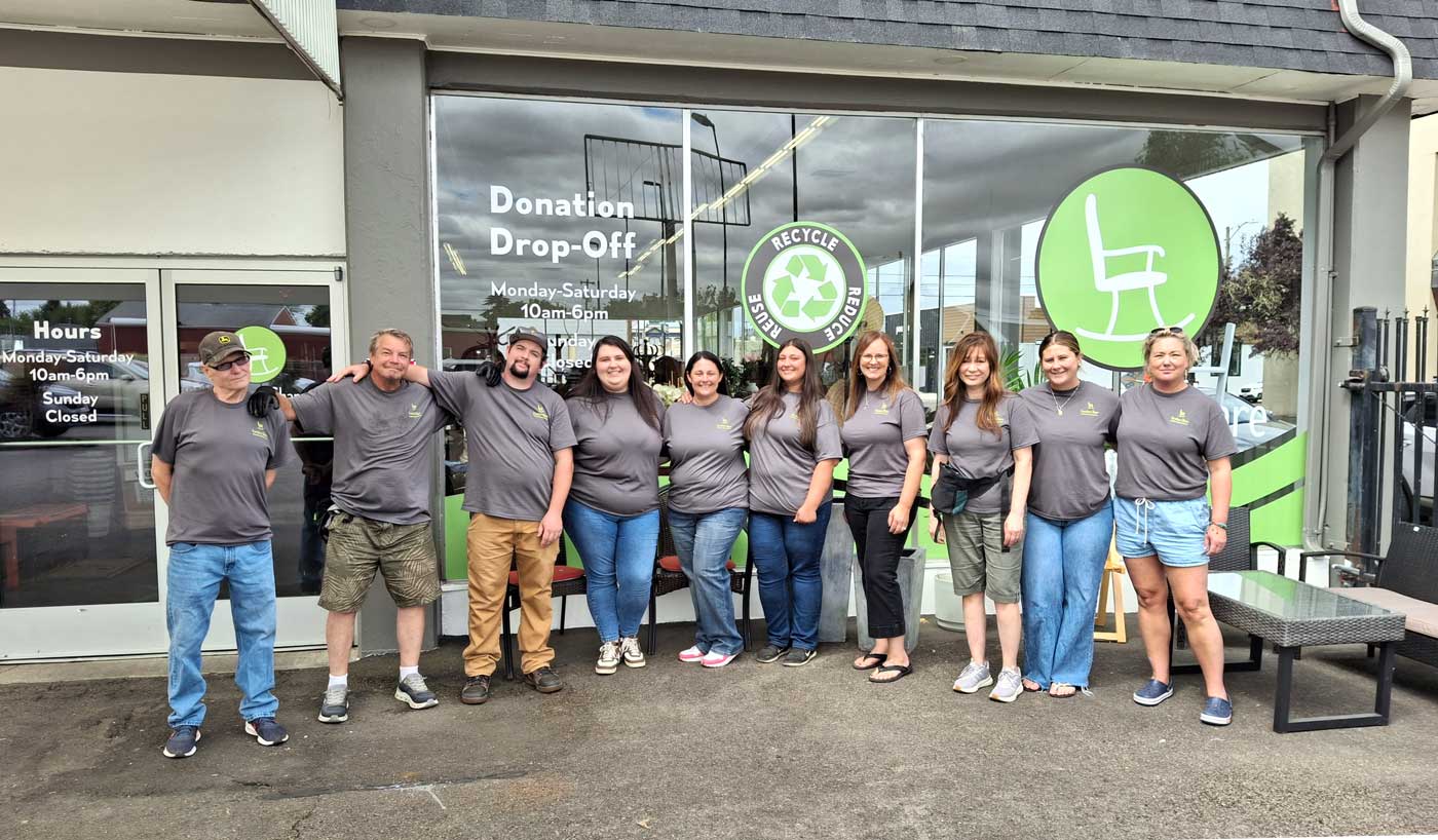 The Furniture Share Thrift Store team standing together outside the storefront in Albany, Oregon